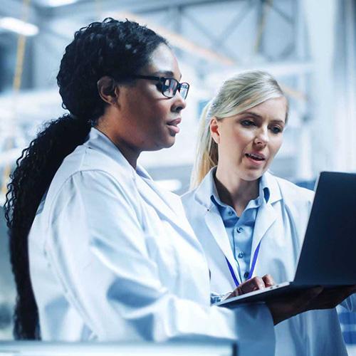 two women scientists working on a laptop