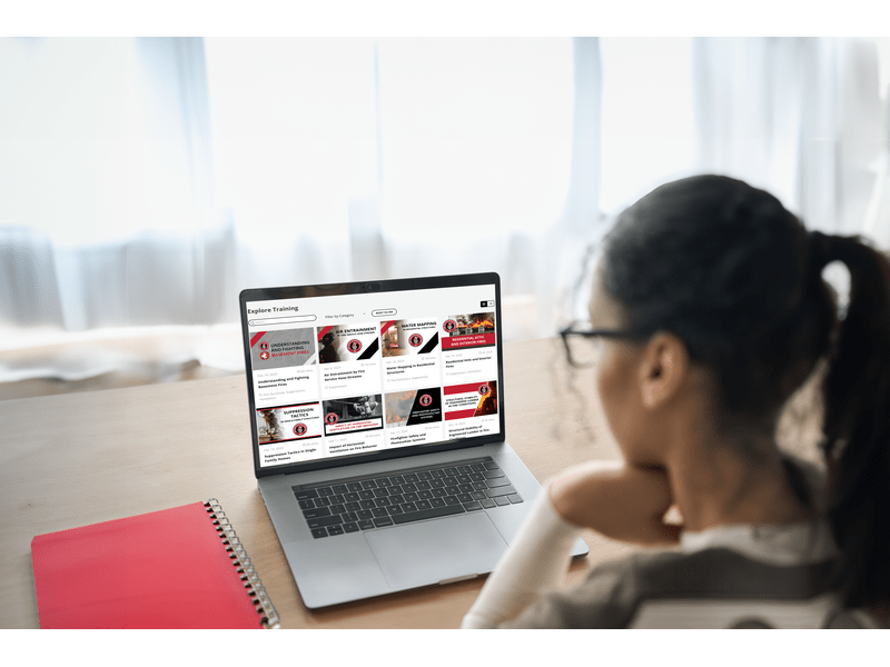 woman looking at laptop with fire safety academy