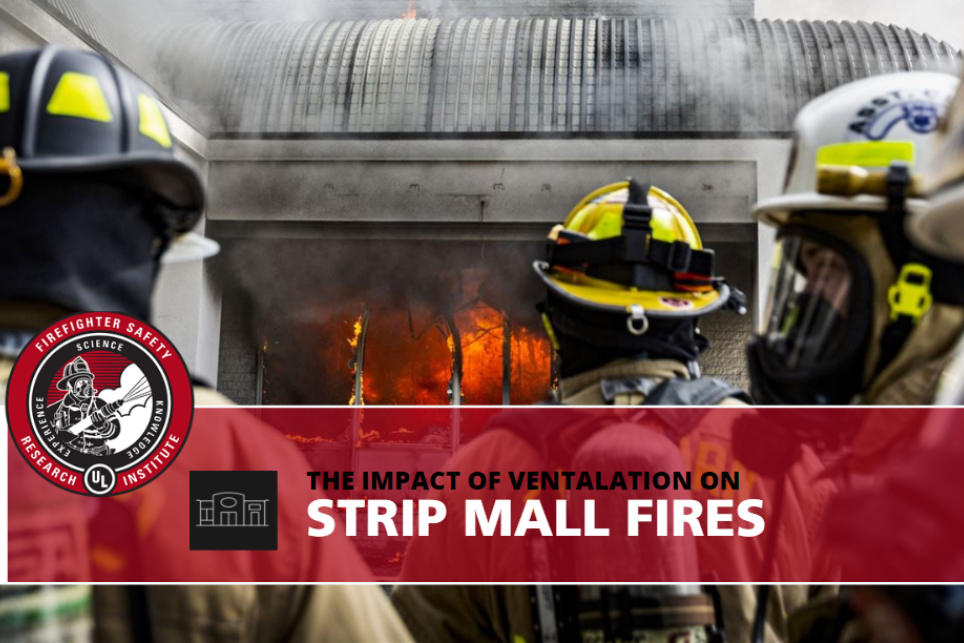 firefighters standing in front of a strip mall on fire