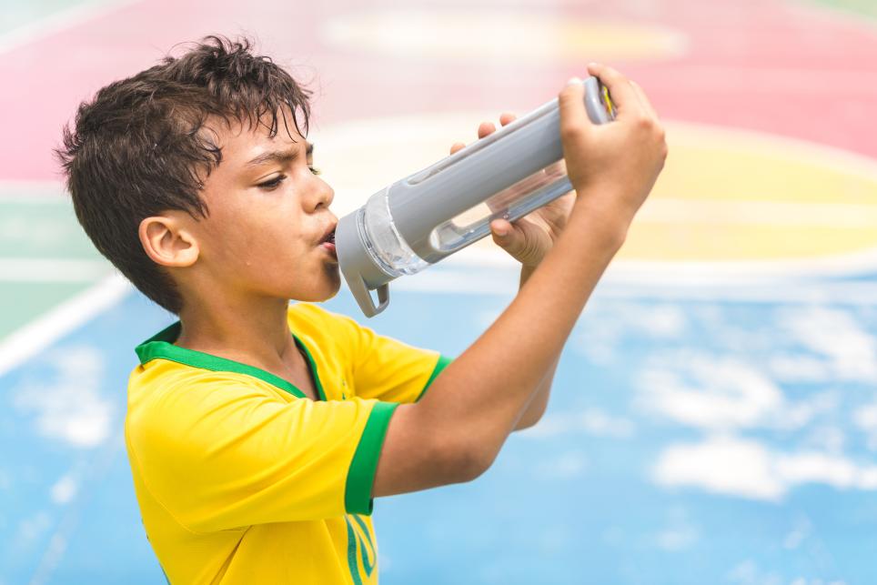 child drinking from a water bottle